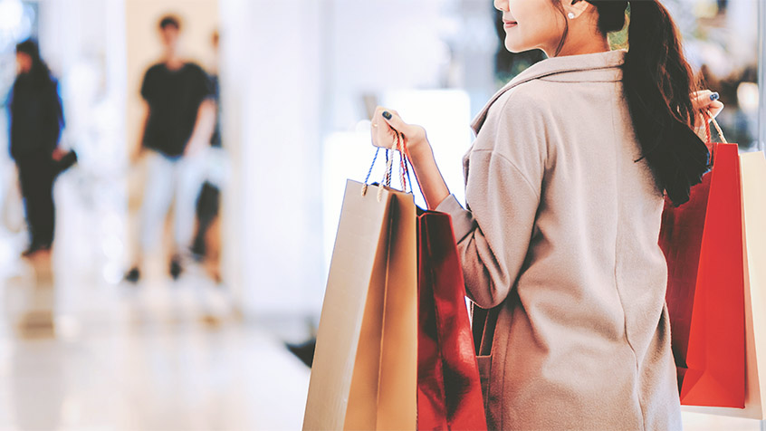 woman holding bags in shopping mall