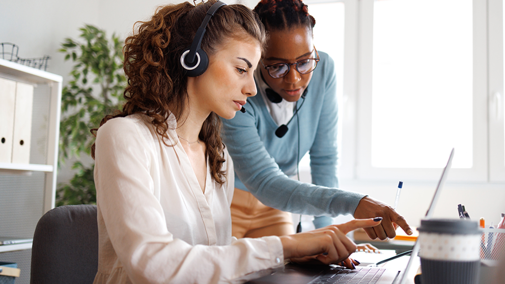 Two women working together on a laptop.