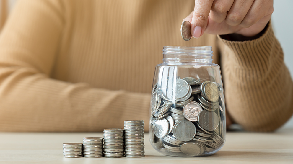 Dropping coins into a jar.