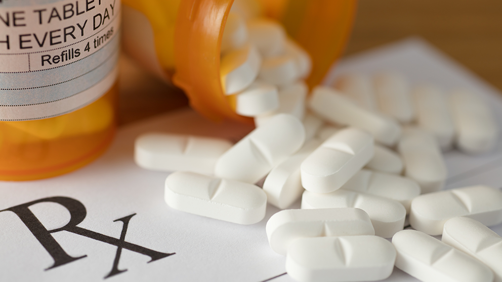 prescription pills poured out of a medication bottle.