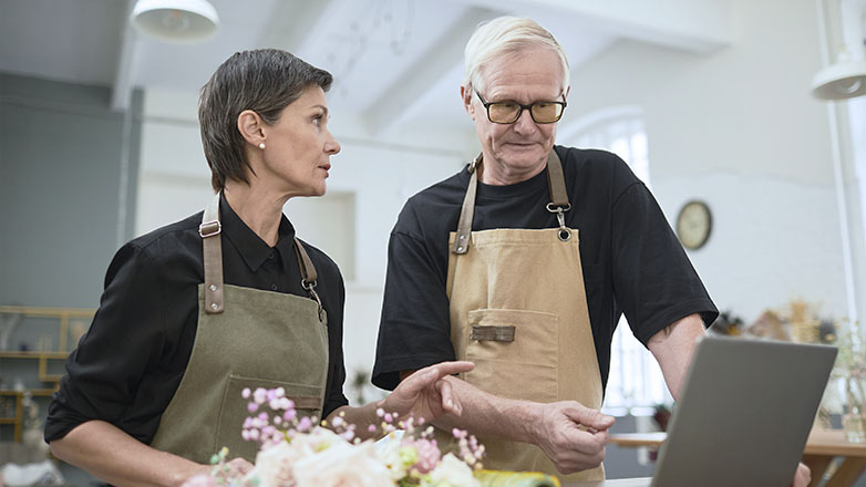 Couple business owners looking at laptop