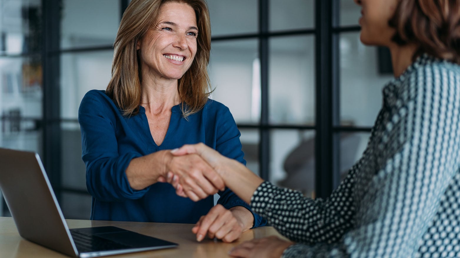 JFG advisor shaking hands with a professional services business client.