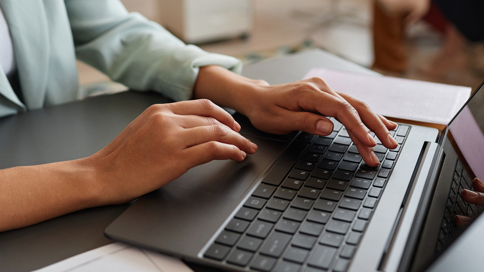 Hands typing on a laptop keyboard.