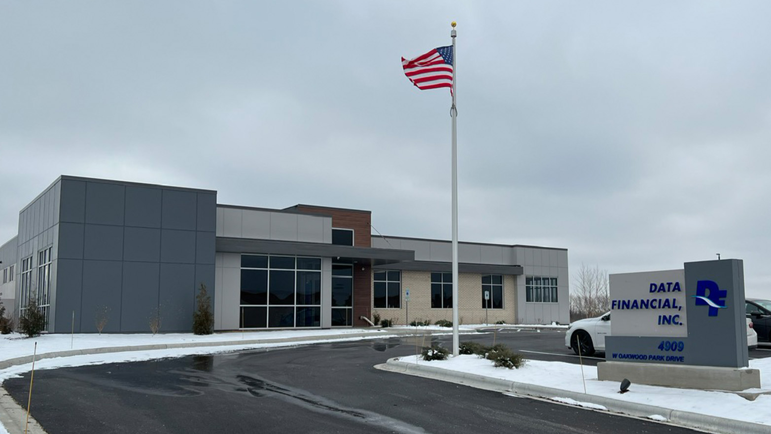 Modern Data Financial, Inc. office building exterior on an overcast day, with an American flag and snow patches.