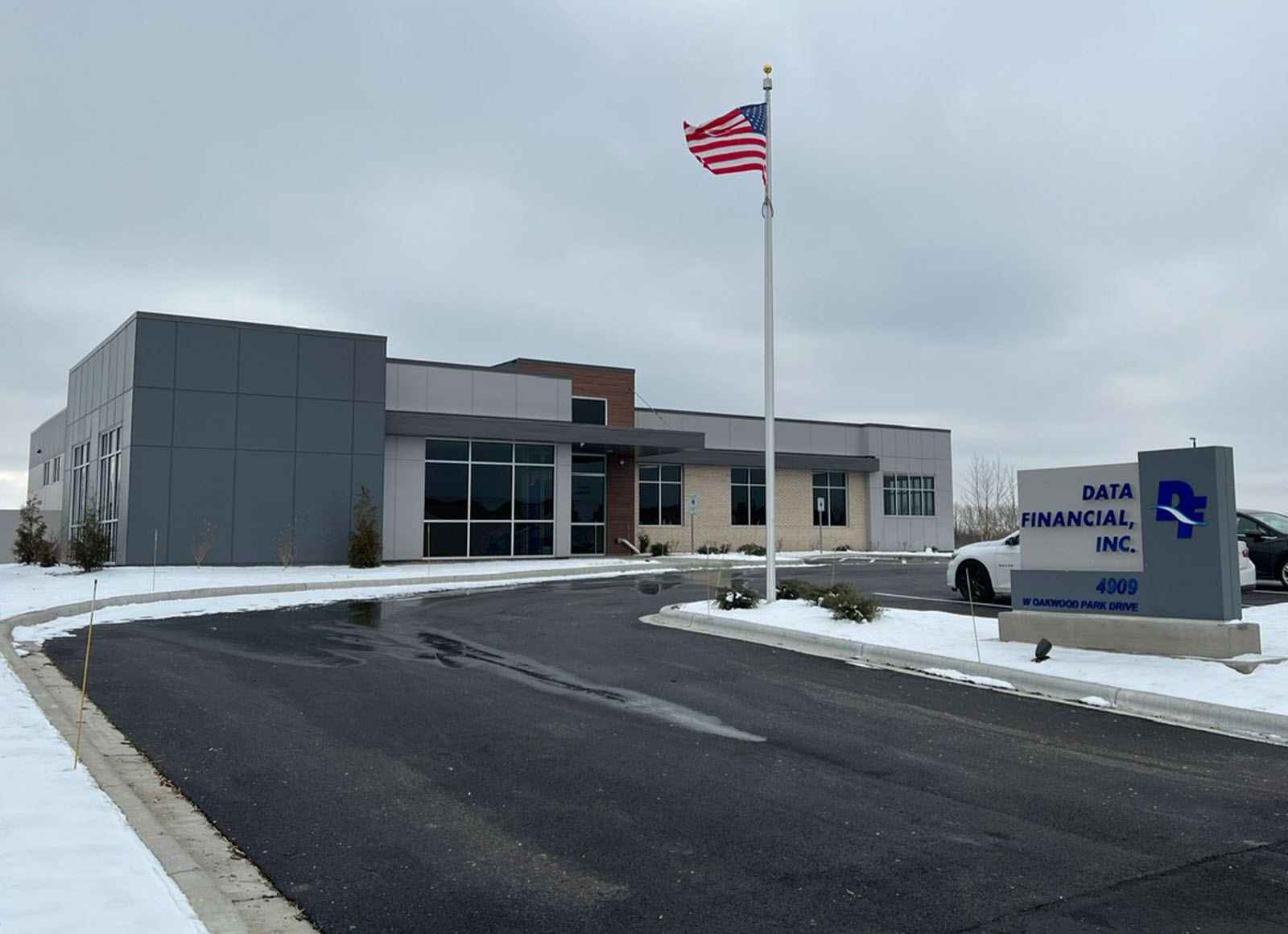 Modern Data Financial, Inc. office building exterior on an overcast day, with an American flag and snow patches.