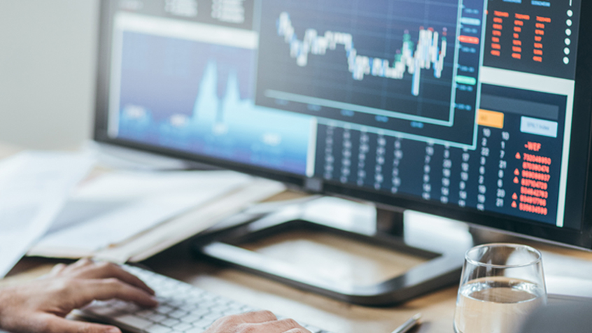 hands at computer showing market performance