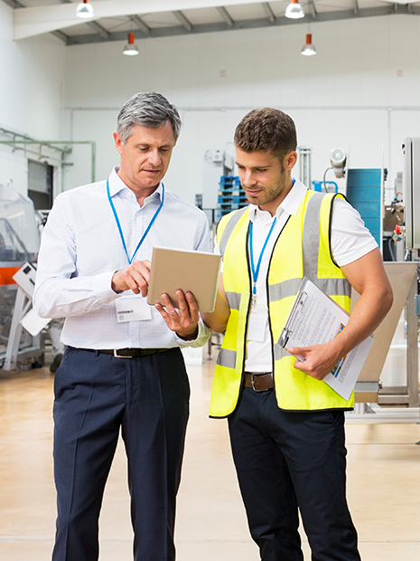 Industry supervisor with employee in the factory.