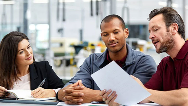 Employees discussing business plans together at the factory.