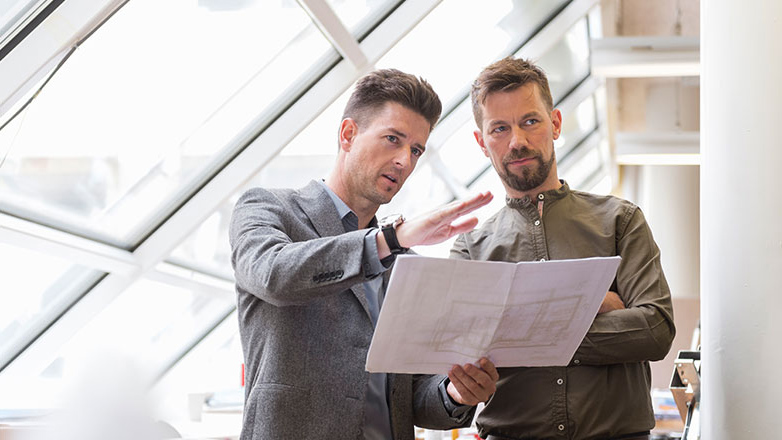 Business owners looking over the plans for their new building.