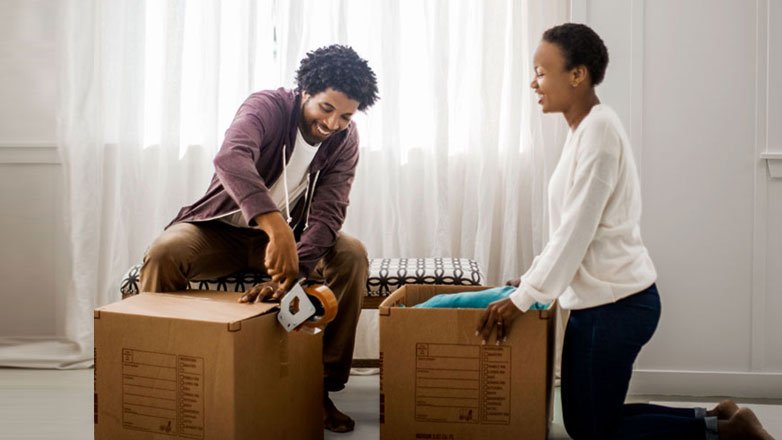 Happy couple packing up the last of their boxes after selling their home.