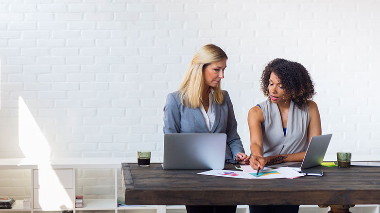 Two female attorneys looking at paperwork.