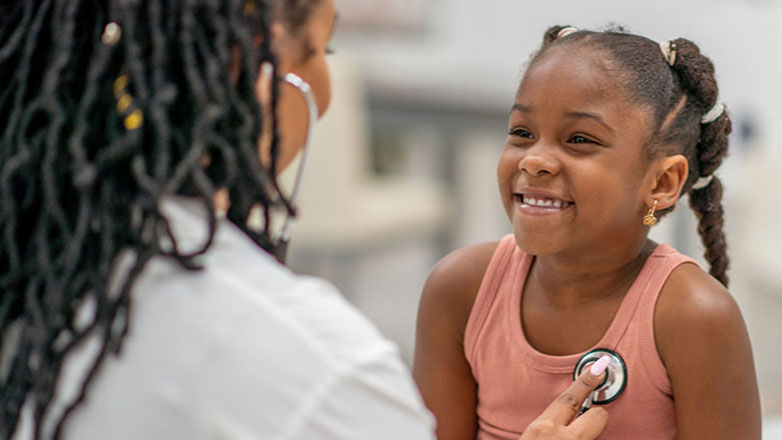 Doctor checks a little girl's heart rate during her appointment.