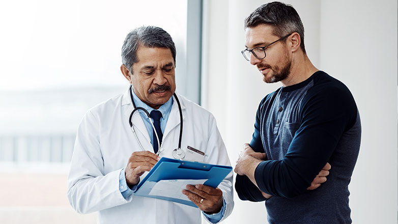 Older male doctor advising male patient.