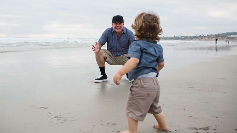 Dad on beach waiting for son to walk to him.