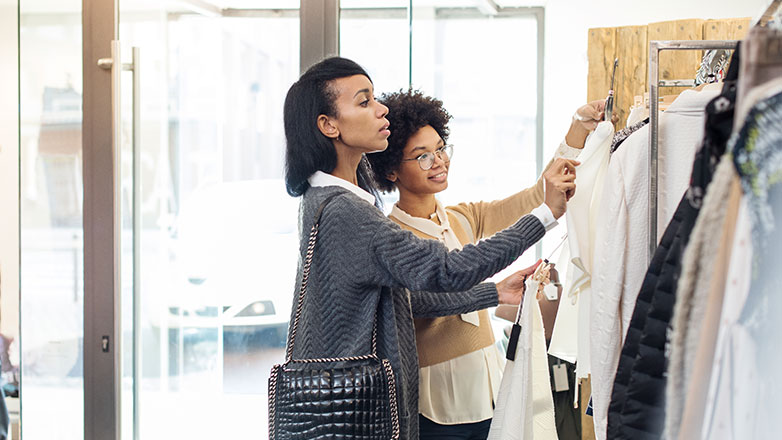 Two female friends shopping in a city setting.