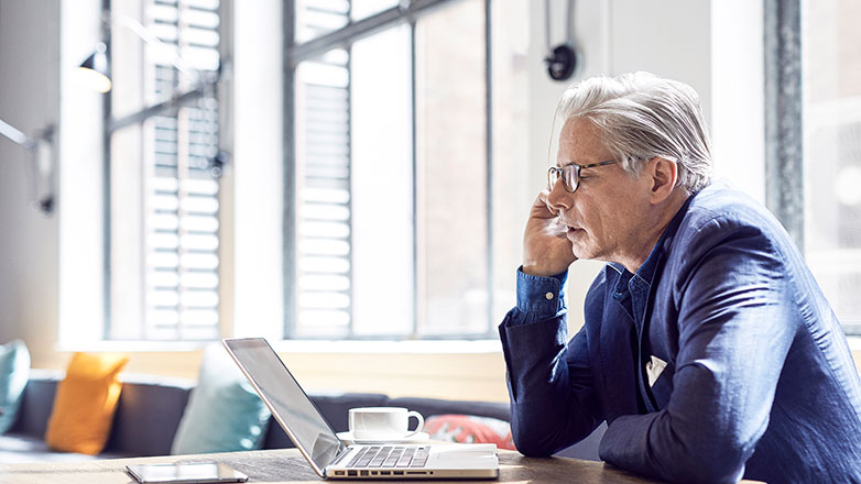 Man talking on phone at his desk.