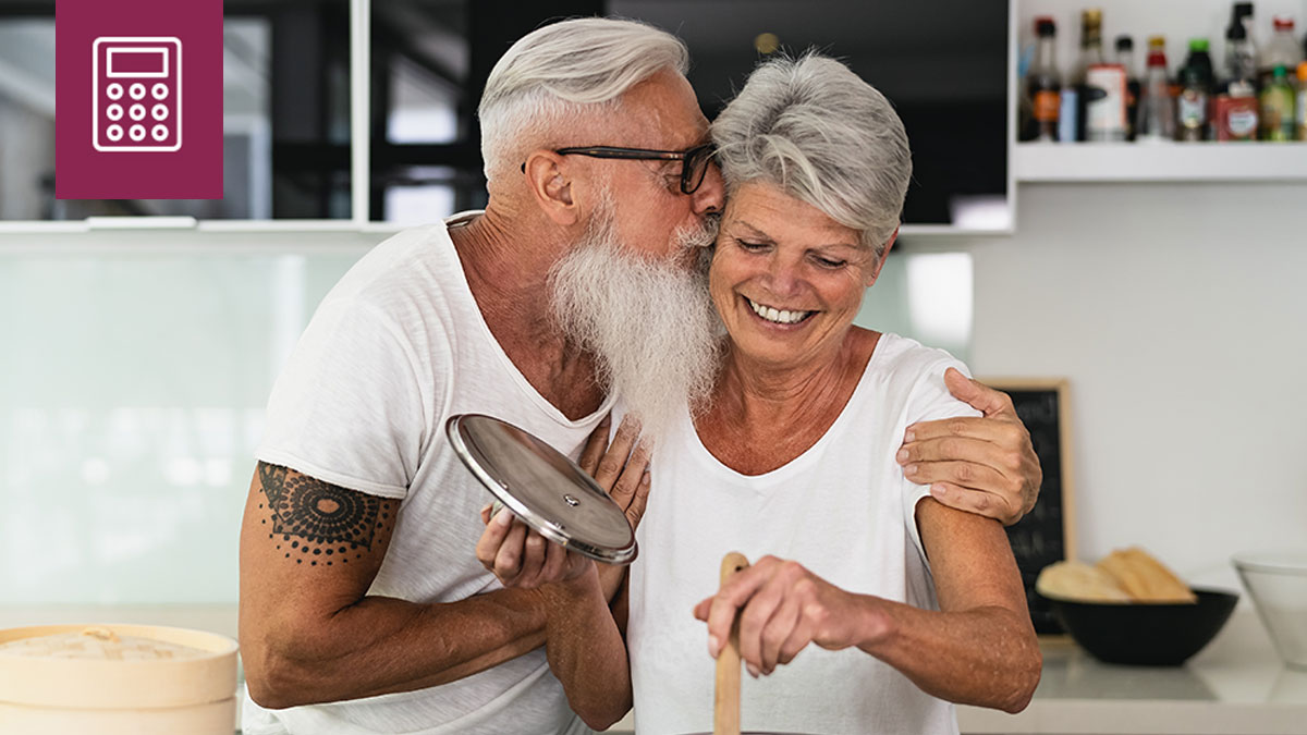 Older couple happily cooking in the kitchen together.