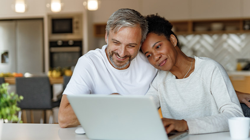 couple in mid-60s looking at a laptop.