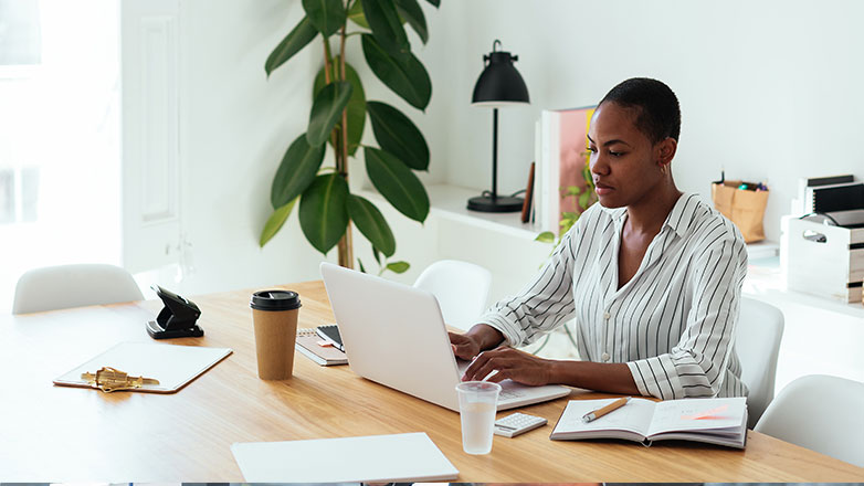 Female professional working on her laptop at her office desk.