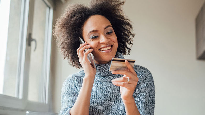 Woman talking with a customer service agent on the phone about her credit card.