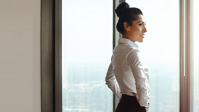 CEO looks out of her office on the top floor of the building.