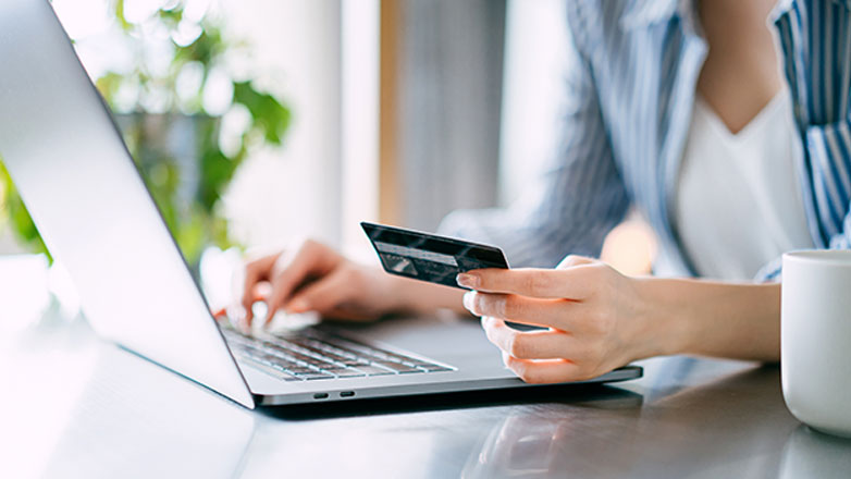 Woman on her laptop making an online payment with her credit card.