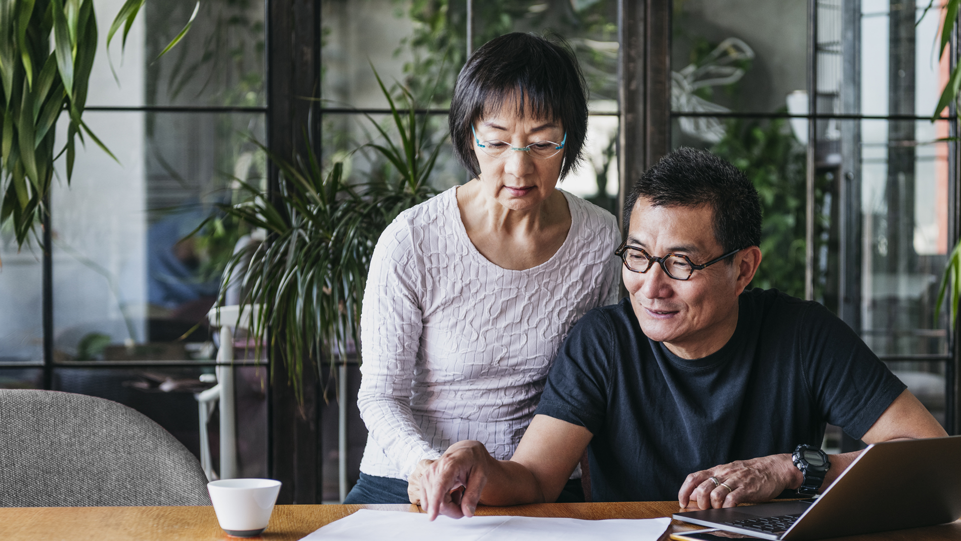 asian american couple with laptop and paperwork