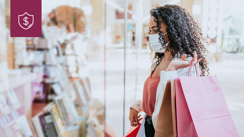 woman with shopping bags looking into shop window.