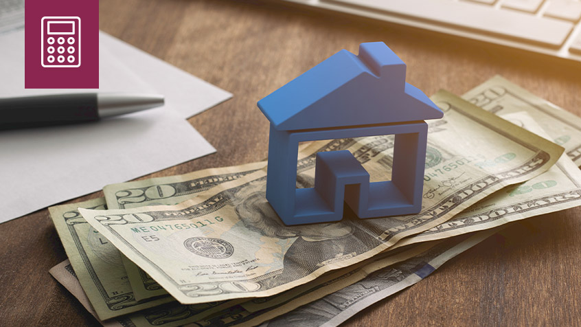 small home model sitting on money