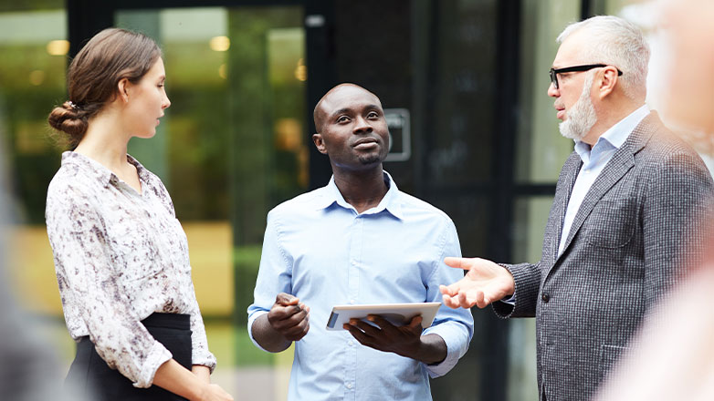 boss talking with coworkers during outside stand-up meeting