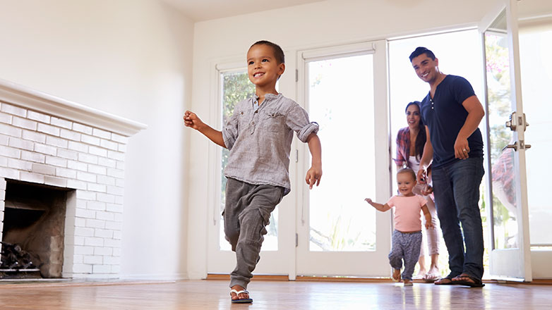 little boy running into room while parents watch at door