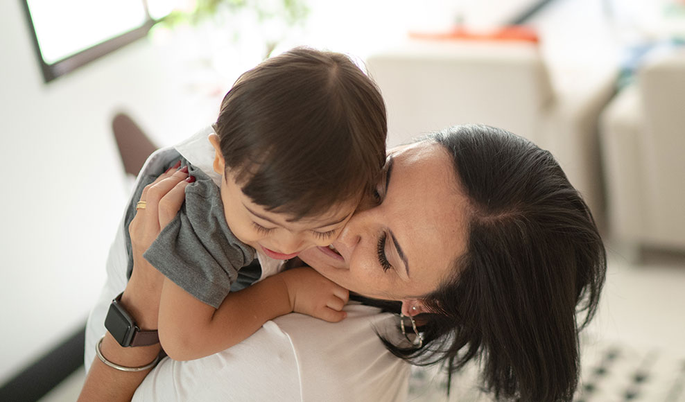 mom holding a baby while smiling