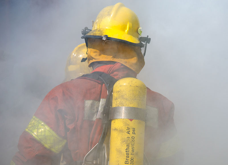 Firefighter makes their way through the smoke-filled air.