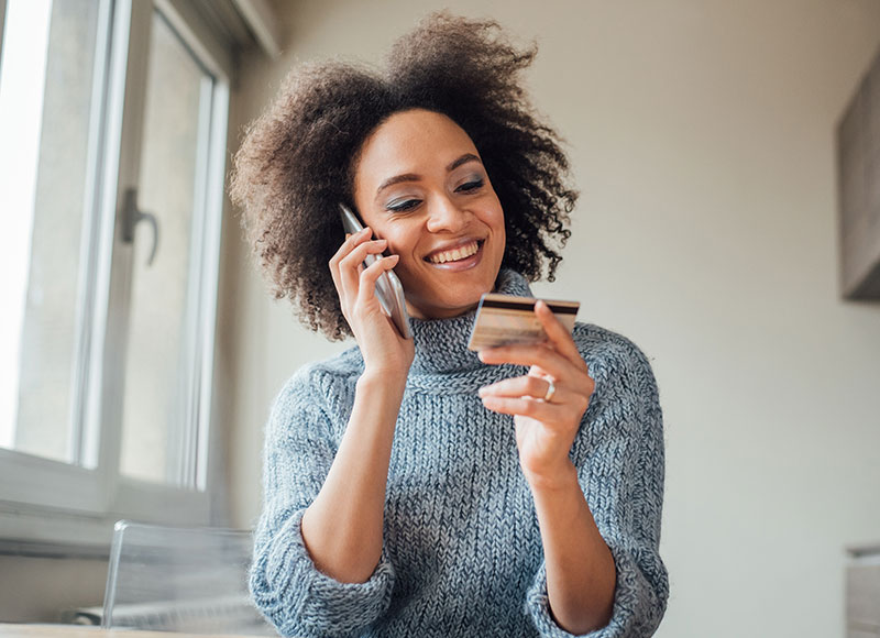 Woman talking with a customer service agent on the phone about her credit card.