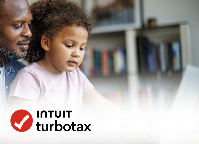 A father helps his young daughter do her taxes on a laptop. Intuit TurboTax logo is in the foreground.