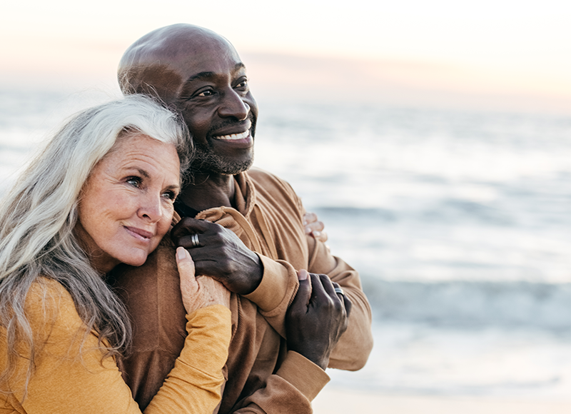 biracial couple walking on the beach