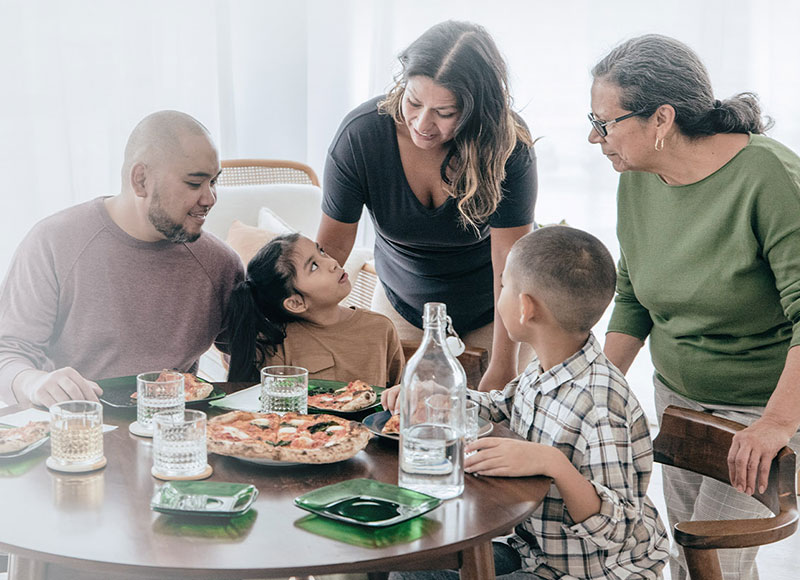 generational family having pizza at the dinner table