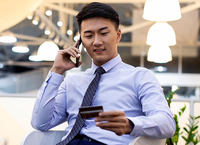 Man uses his credit card to pay for a purchase over the phone.