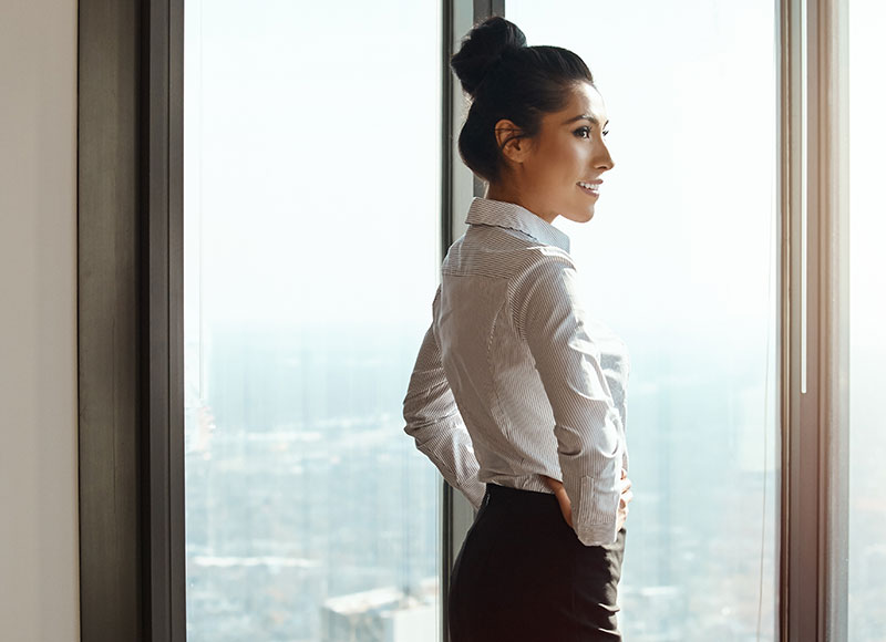 CEO looks out of her office on the top floor of the building.