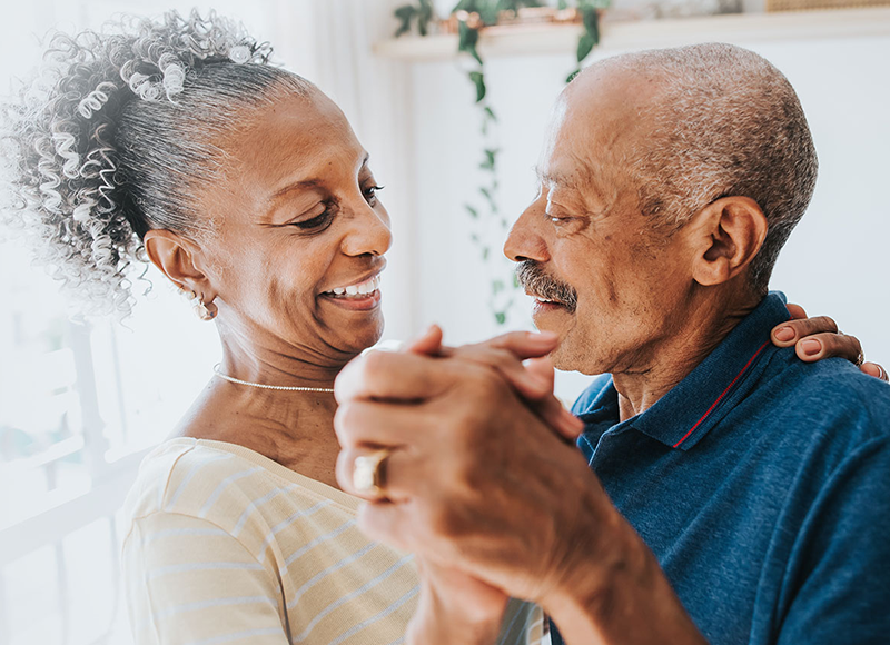 Retired couple dancing together in their kitchen,