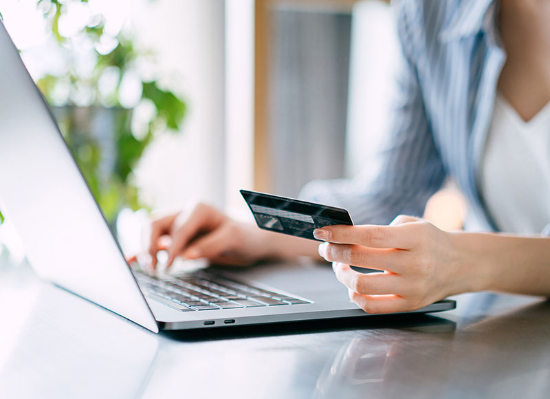 Woman on her laptop making an online payment with her credit card.